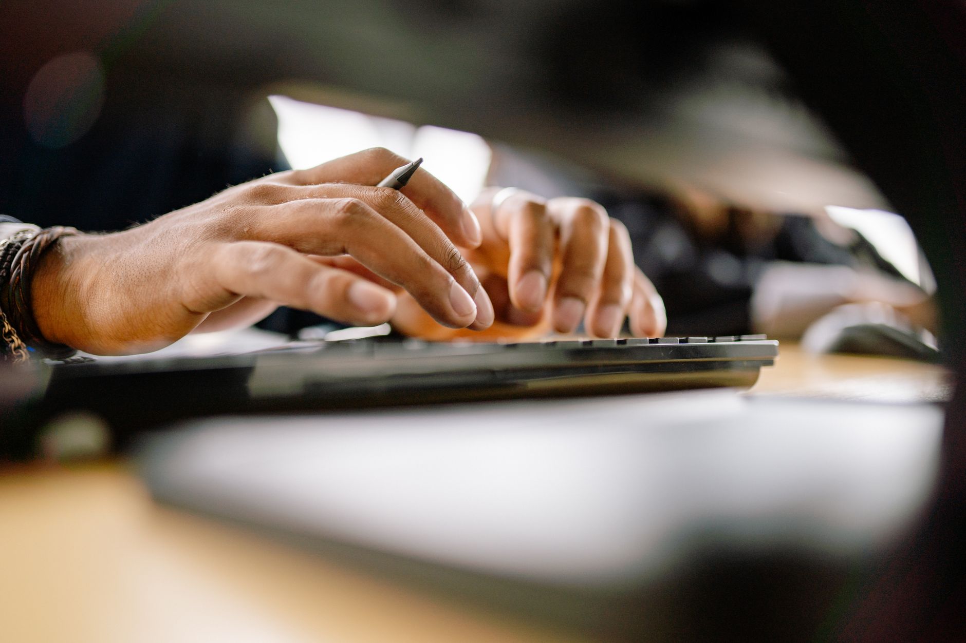 Person typing on a split ergonomic keyboard with tented halves at a clean desk