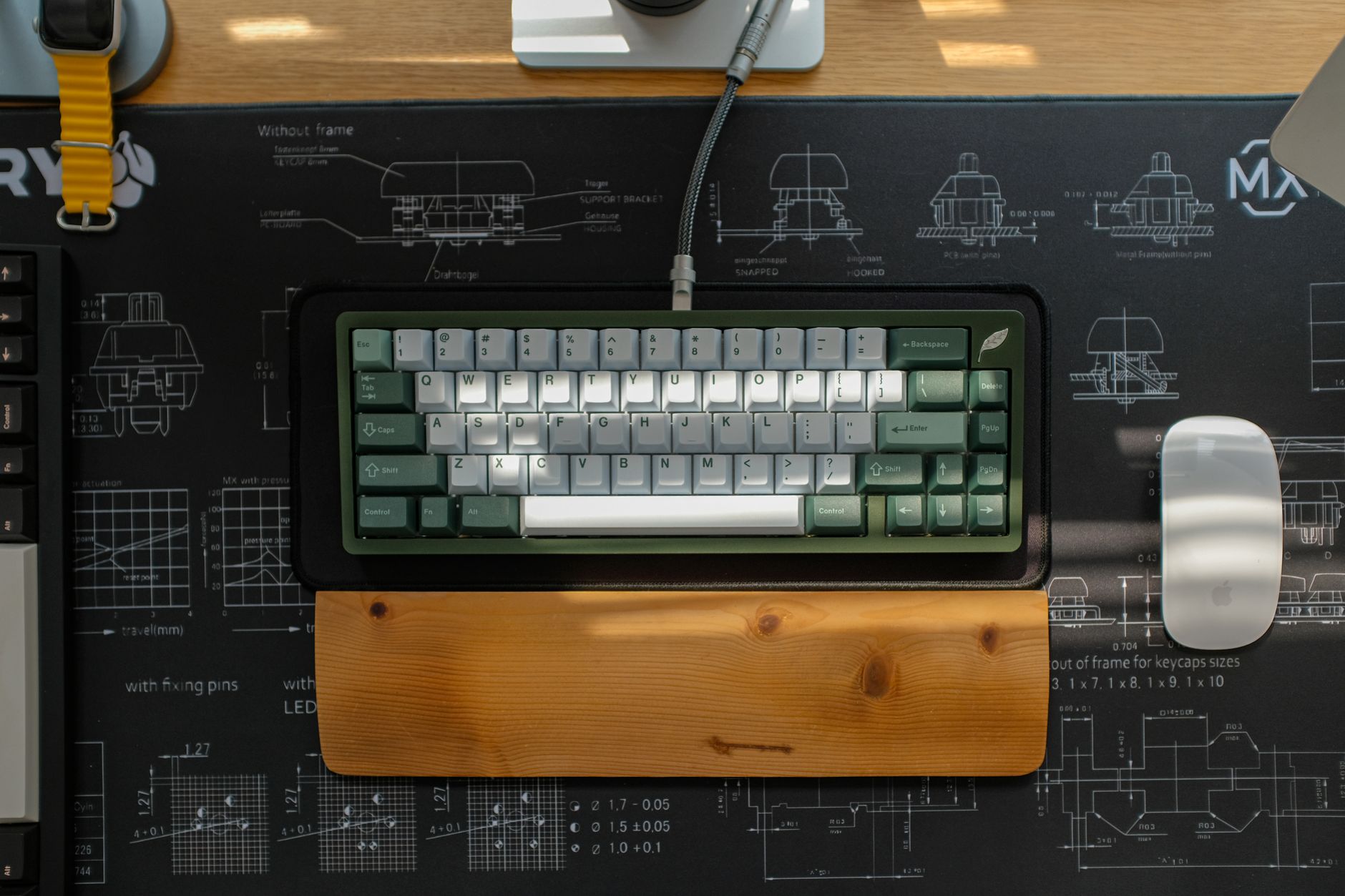 A curved ergonomic keyboard with an integrated wrist rest sitting on a white desk