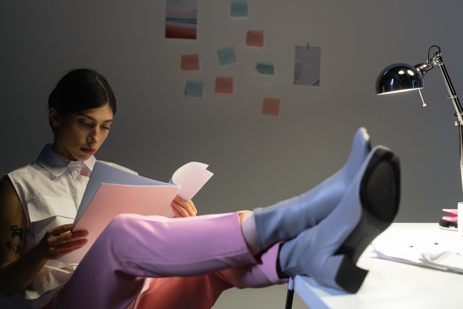 A woman sitting at a desk with her feet flat on an adjustable footrest under the desk