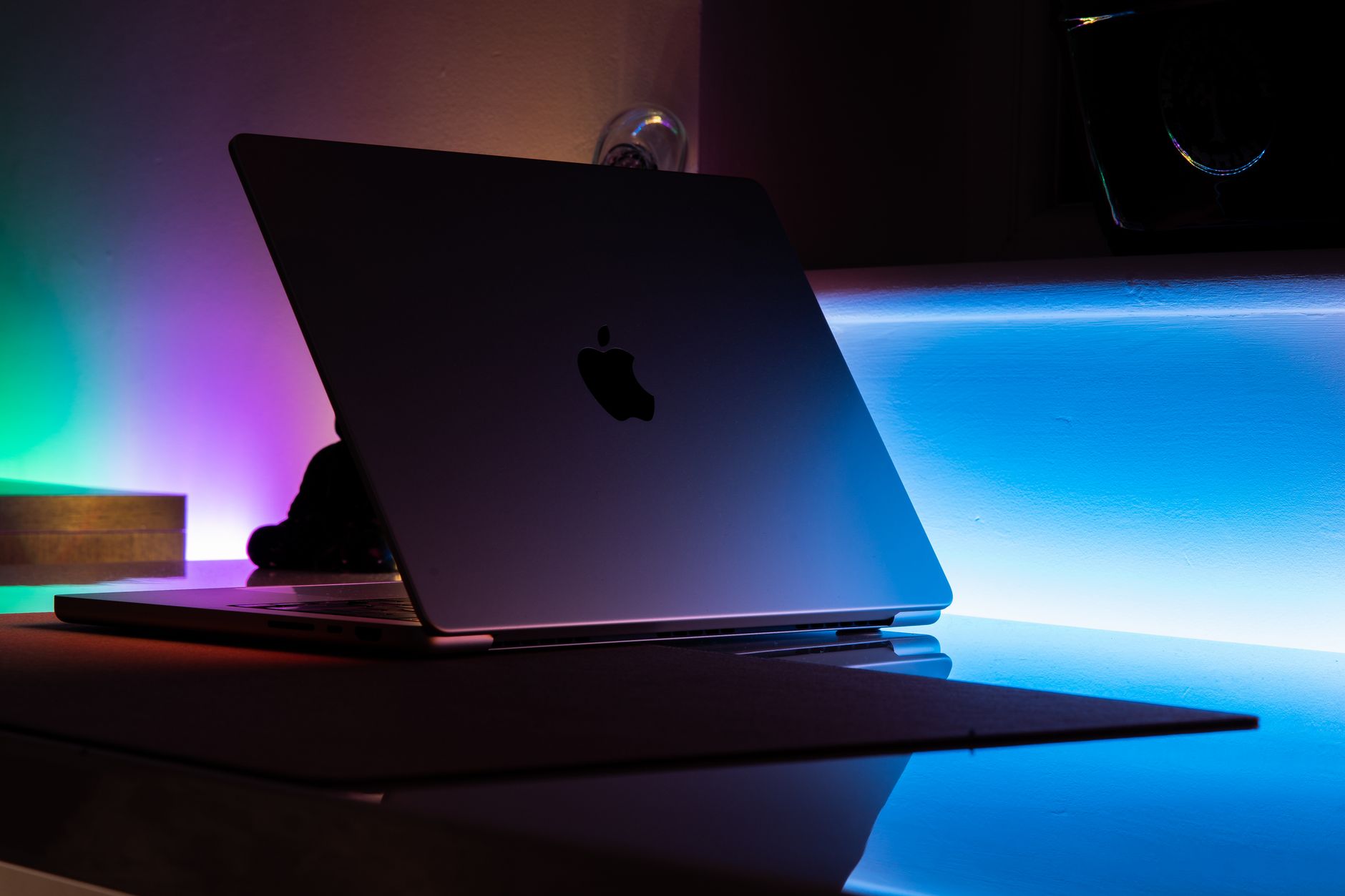 Silver aluminum laptop stand holding a laptop next to a desk lamp