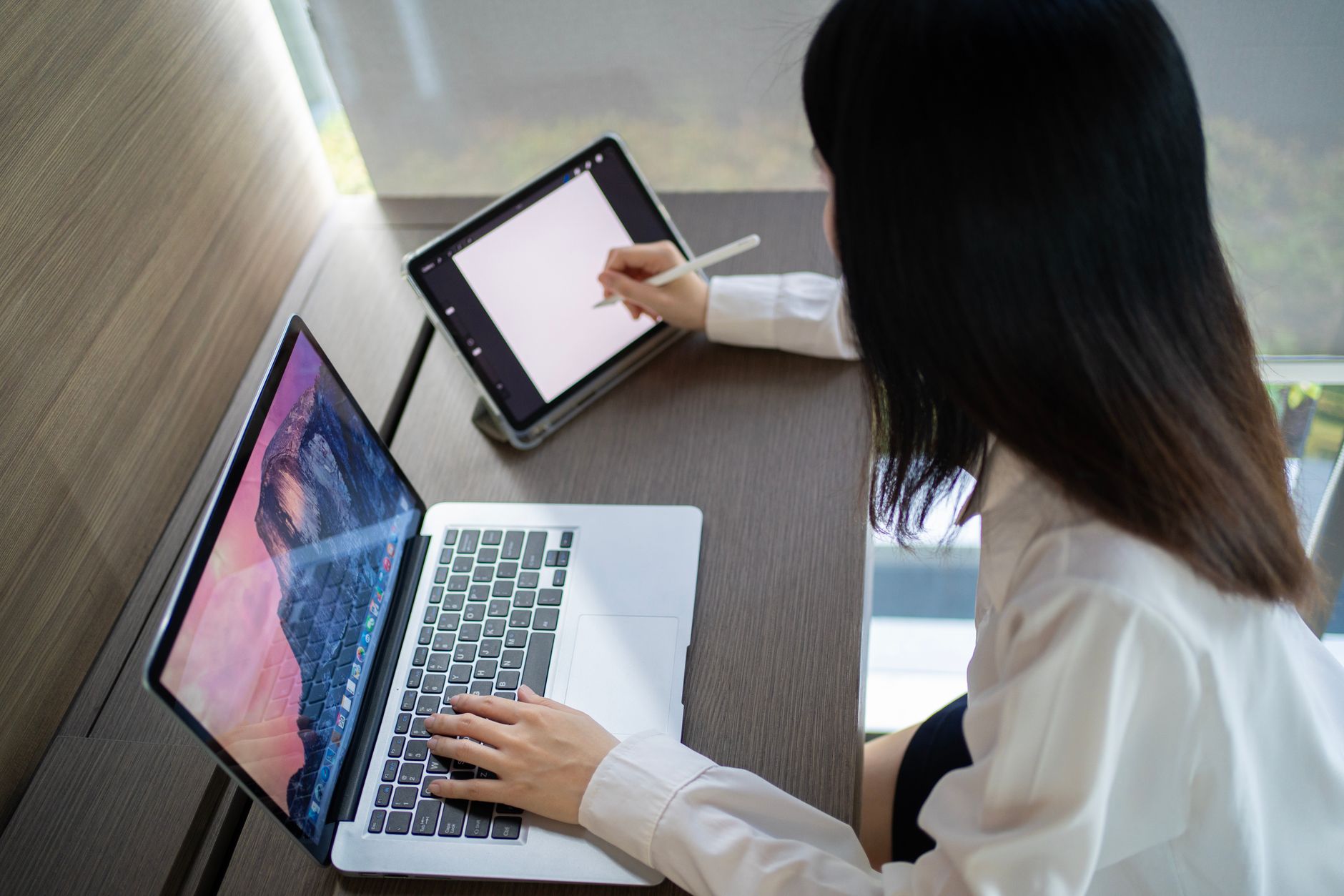 Person raising a VariDesk standing desk converter at a home office desk