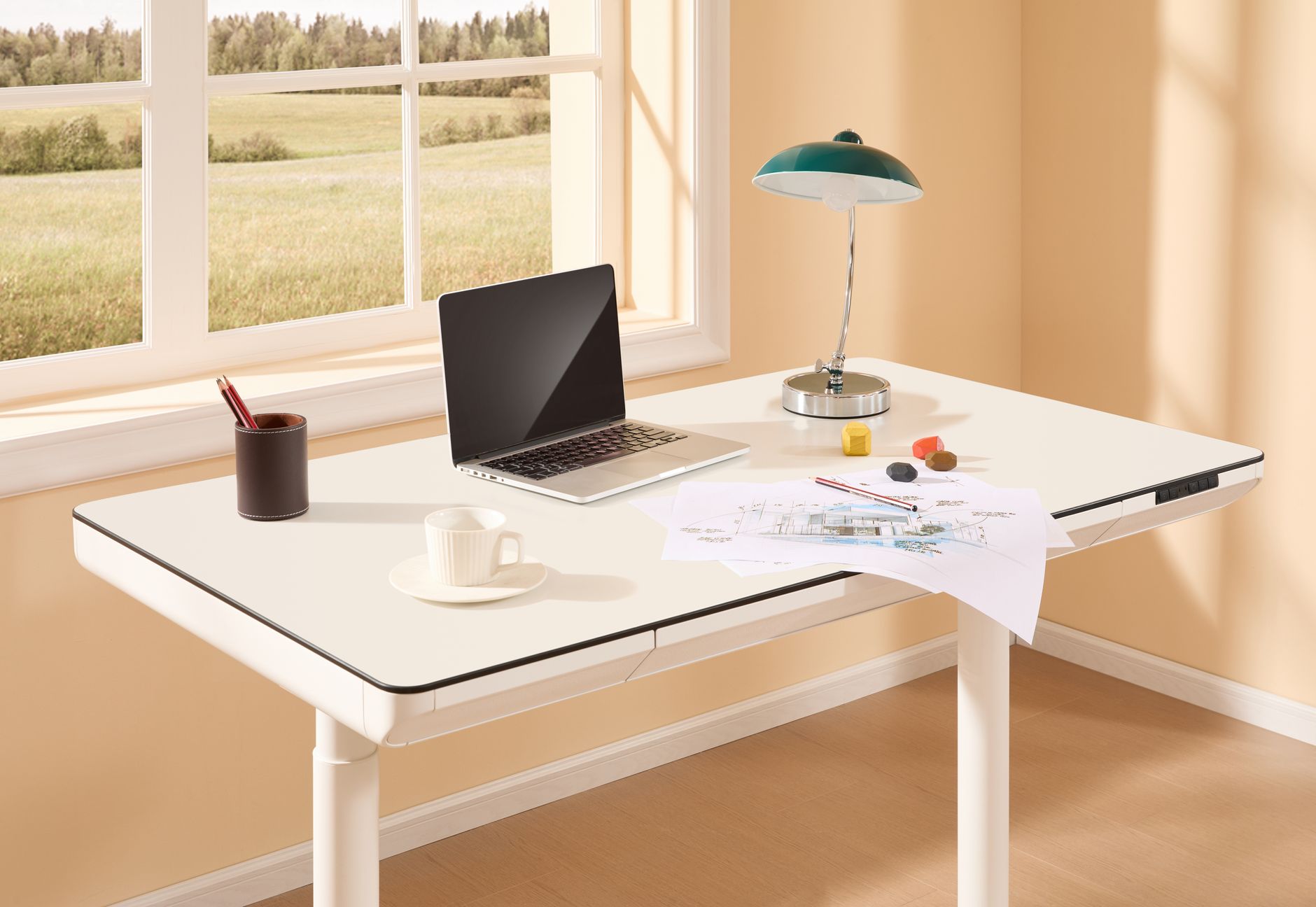 A person raises a dual motor standing desk in a bright home office.
