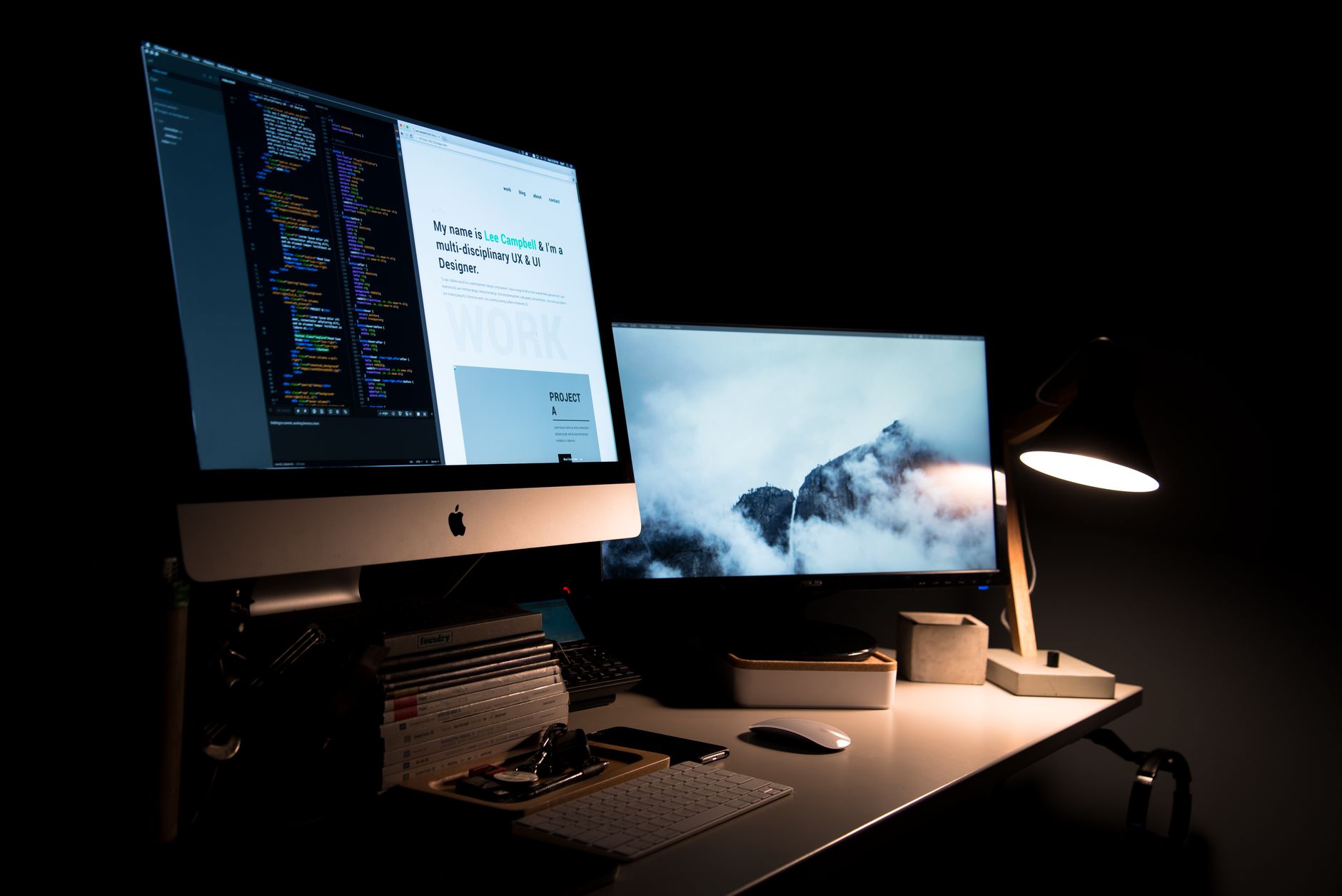 Warm desk lamp lighting an office desk next to a computer monitor