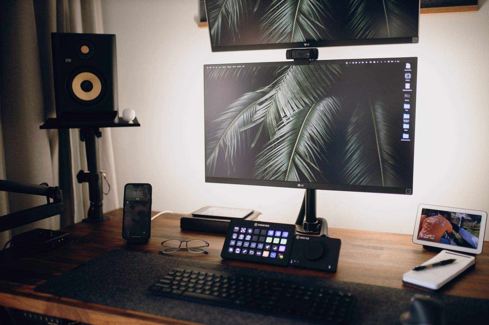 Smartphone resting on a charging pad beside an adjustable standing desk keypad