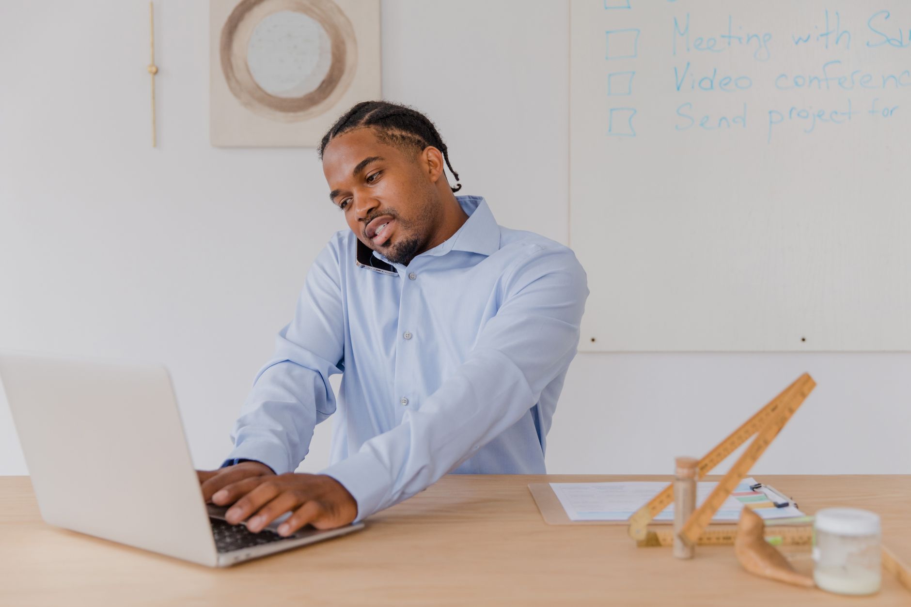 Tall man typing on a laptop while standing at a raised desk