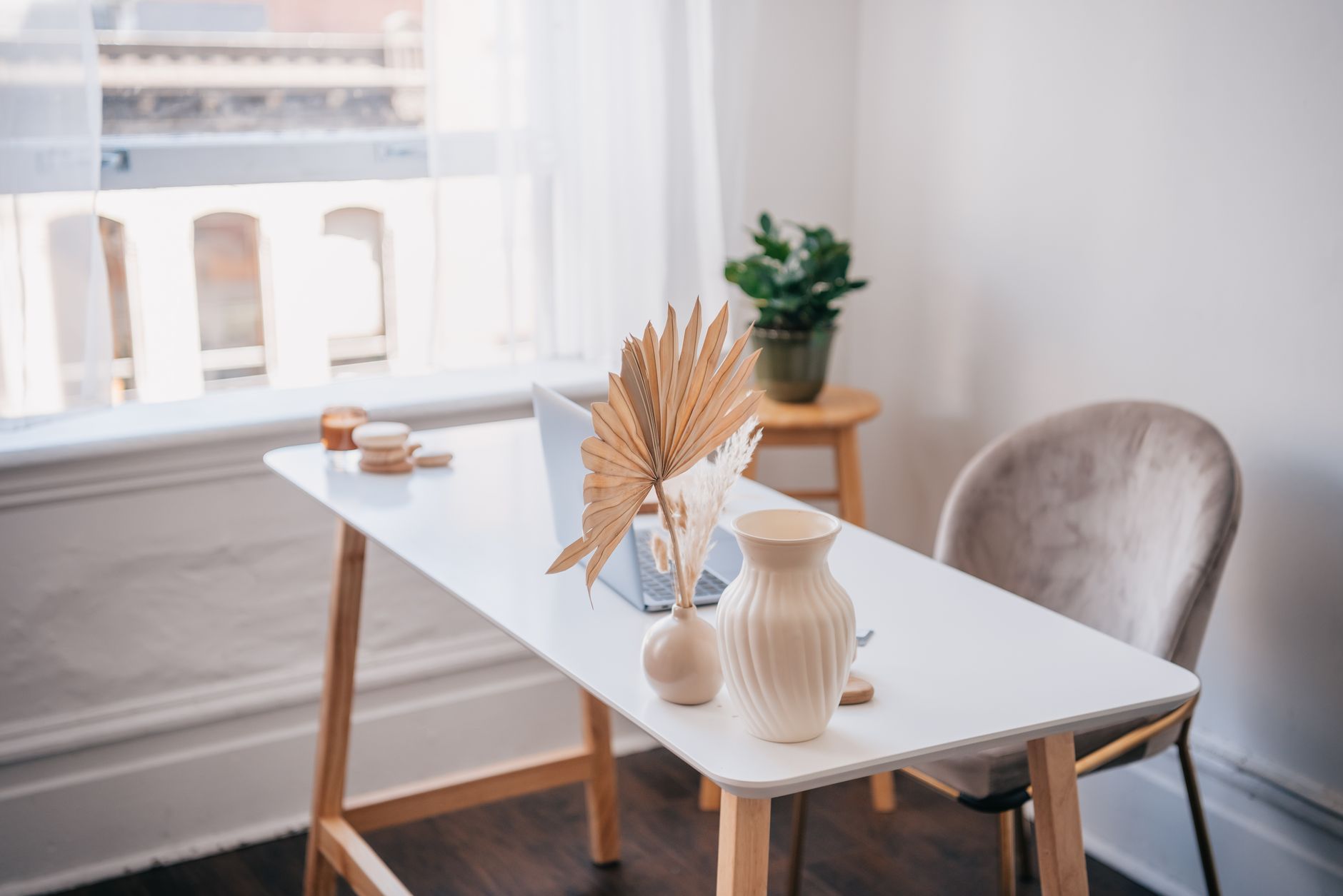 Bamboo topped standing desk with a laptop in a bright home office