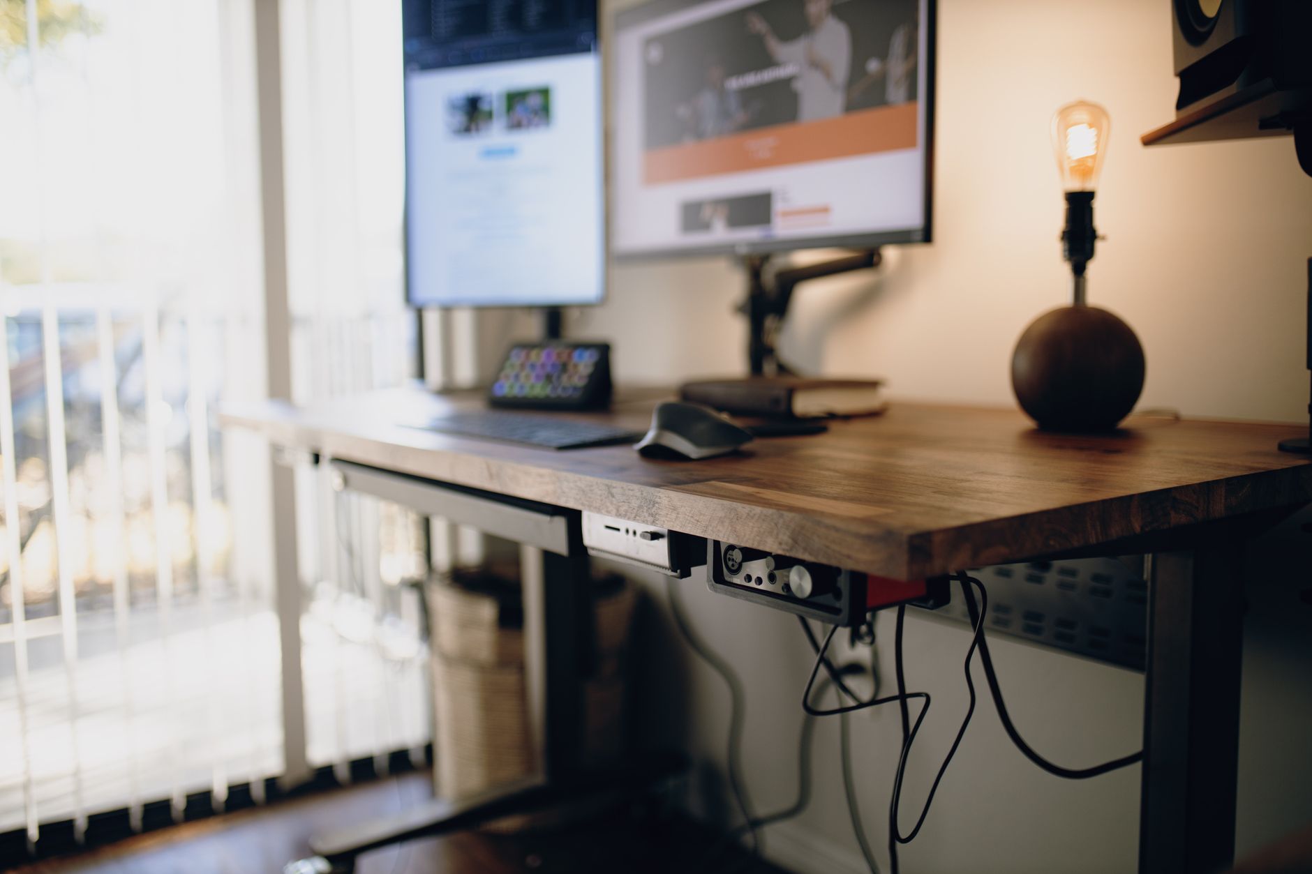a person adjusting a computer monitor height on a desk in a home office