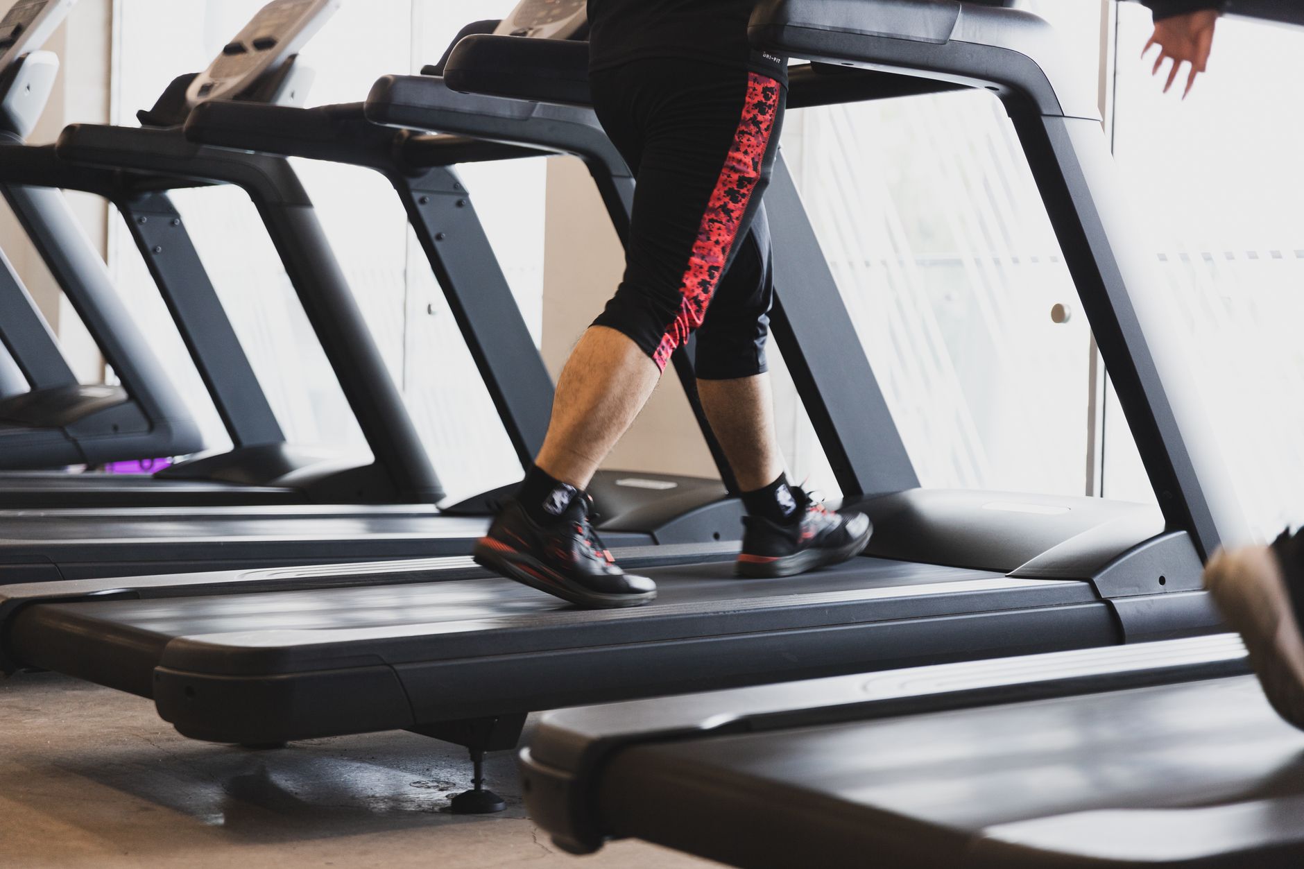 Close up of feet in sneakers walking on a padded treadmill belt