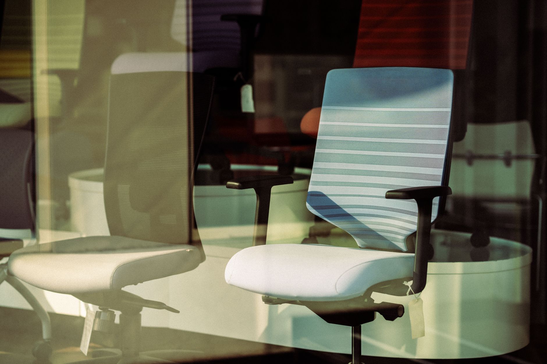 a person adjusting the height of an ergonomic office chair at a desk