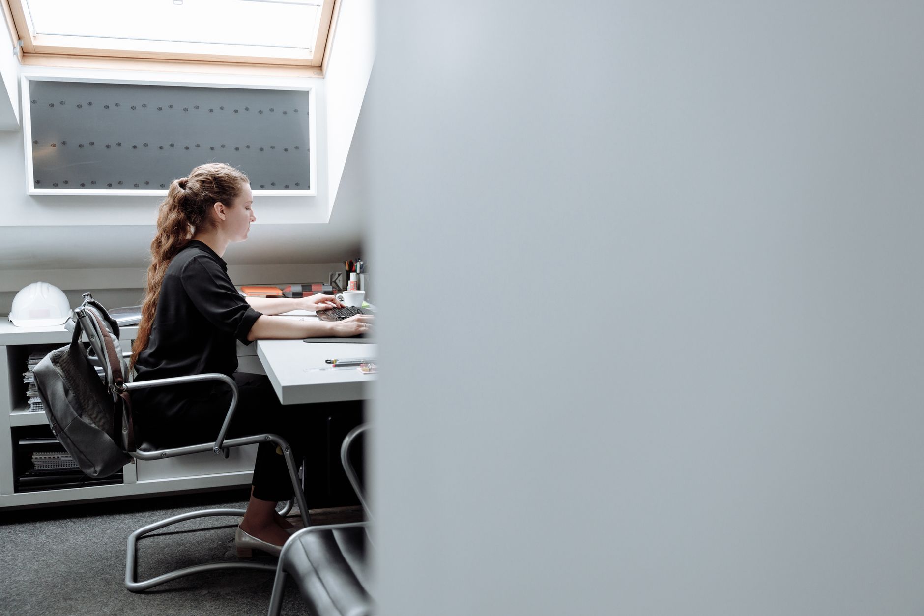 a person measuring the top of a monitor at an ergonomic workstation